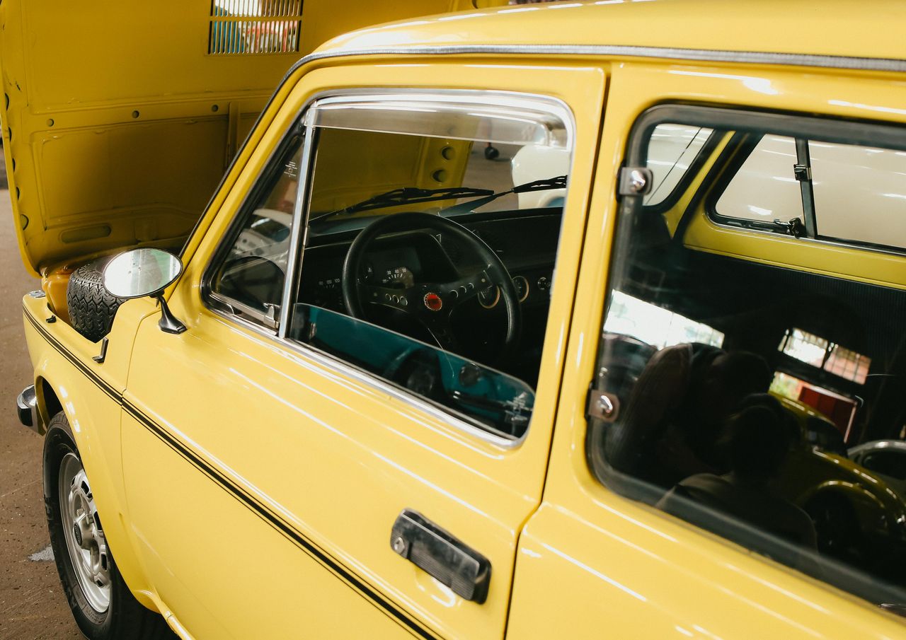 Close-up of a vintage yellow car interior with open hood in Presidente Prudente, Brazil.